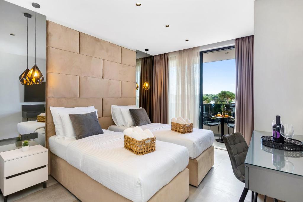 two beds in a hotel room with a desk and a table at Fly Room - S7 - MPolo in Medulin