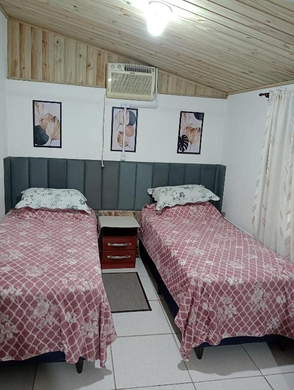 two beds sitting next to each other in a room at Cantinho do lar in Timbó