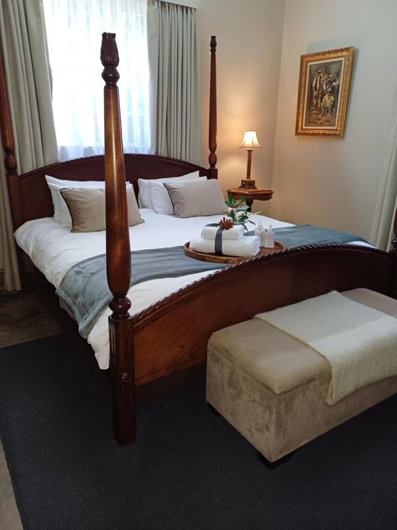 a bedroom with a large bed with a wooden frame at Bowden B&B in Olifantshoek