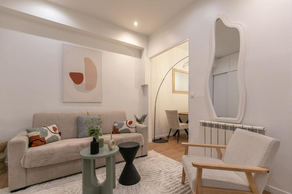 un salon avec un canapé et une chaise dans l'établissement MBA - Courcelles - Splendide Appartement, à Paris