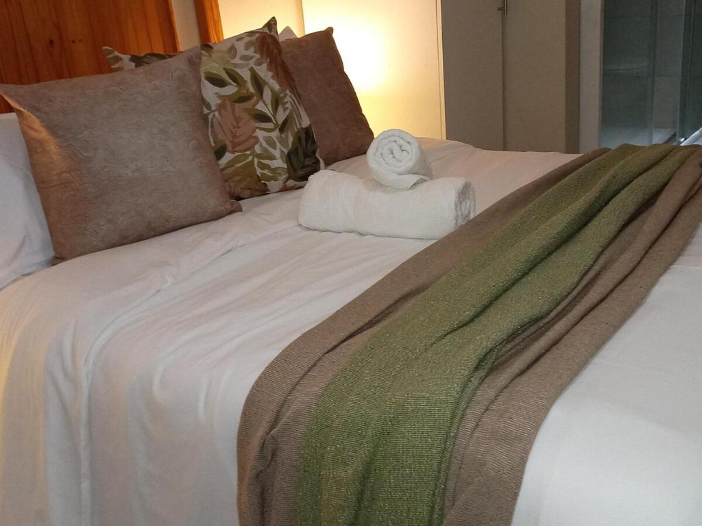 a bed with a pile of towels on it at Simple stay in East London