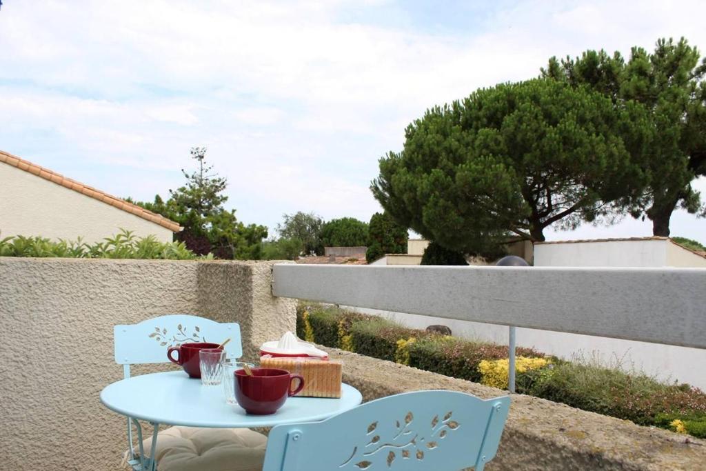 Una mesa y sillas en un balcón con vista. en Appartement 2 pièces 4 couchages Dolus d'Oléron DDO000-008, en Dolus d'Oléron