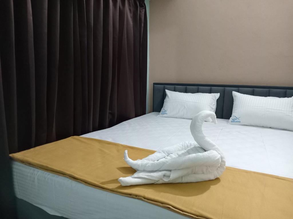 a swan made out of towels sitting on a bed at The Triple Nest in Gokarna