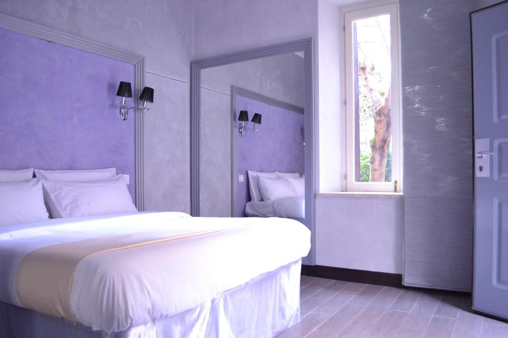 ein Schlafzimmer mit einem großen weißen Bett und einem Fenster in der Unterkunft Tiburtina House in Rom