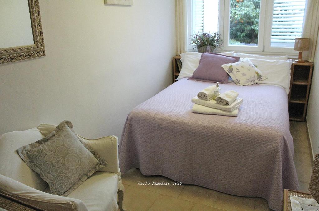 a bedroom with a bed with towels and a chair at Villa Apollo B&B in Capri