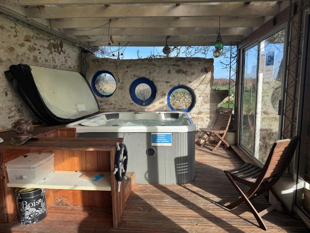 - une cuisine avec une baignoire, une table et des chaises dans l'établissement Gites de la Meitairie, à Bignan