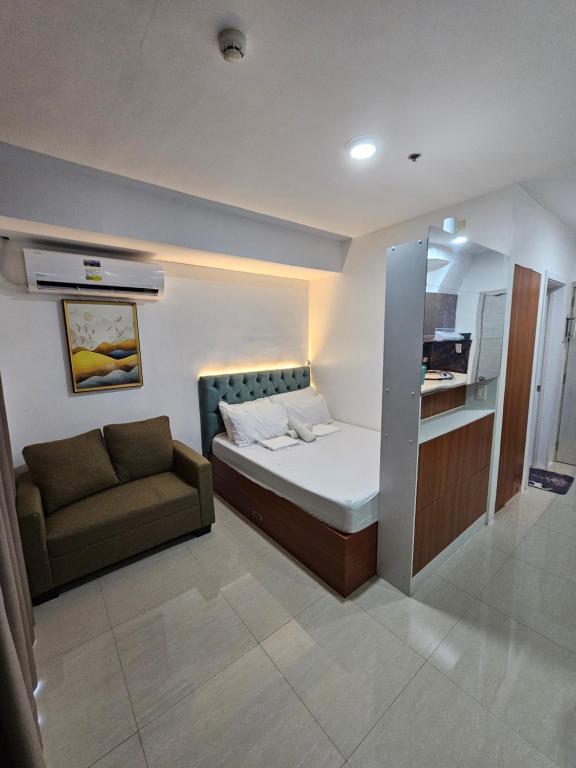 ein kleines Schlafzimmer mit einem Bett und einer Couch in der Unterkunft 1802 West Jones Residences in Cebu City
