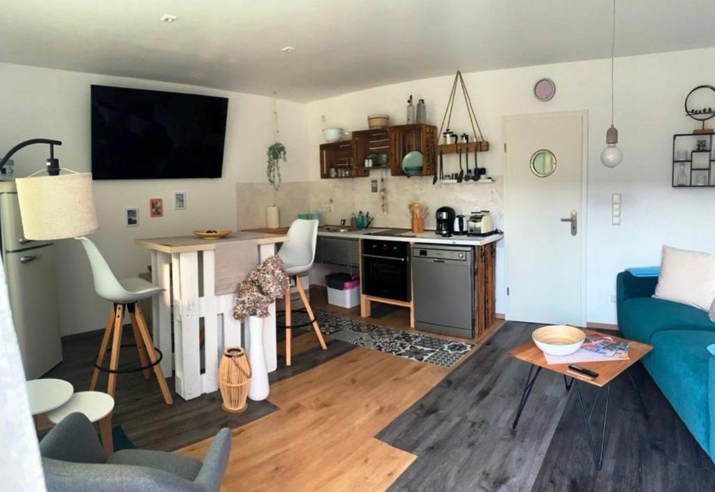 Alt ReddevitzにあるFerienwohnung nordisch Kühlの青いソファとキッチンのあるリビングルーム