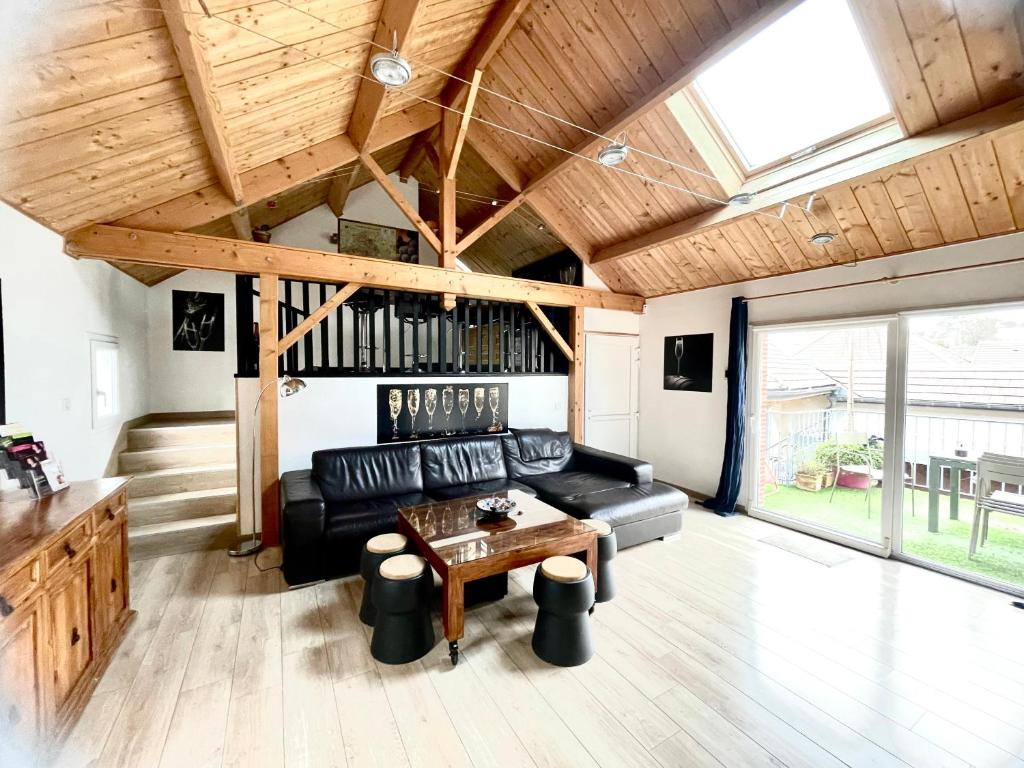 a living room with a black couch and a table at Le Lodge Champenois in Épernay