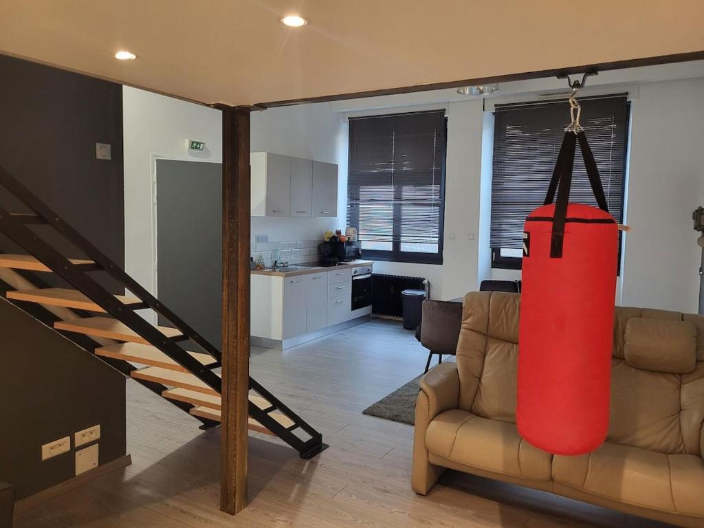 - un salon avec un grand objet rouge suspendu au plafond dans l'établissement Le Loft, à Épinal