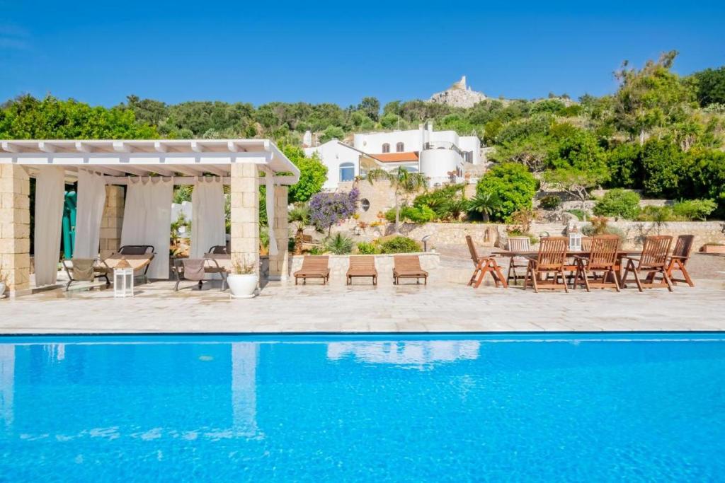 a villa with a swimming pool and a patio at Villa Torre del Sasso in Marina Porto