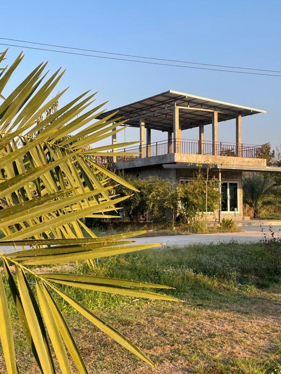 a building with a large yellow sculpture in front of it at DHome and Gardens in Phibun Mangsahan