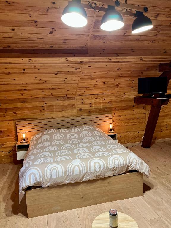 une chambre avec un lit dans une cabane en rondins dans l'établissement Studio Les Glycines, à Pouilly-les-Nonains