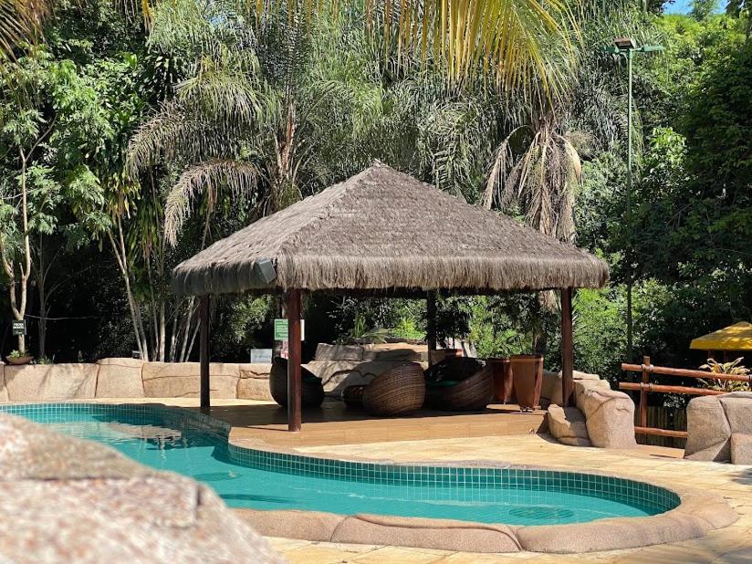 una sombrilla grande junto a la piscina en Thermas do Bosque, en Jeriquara