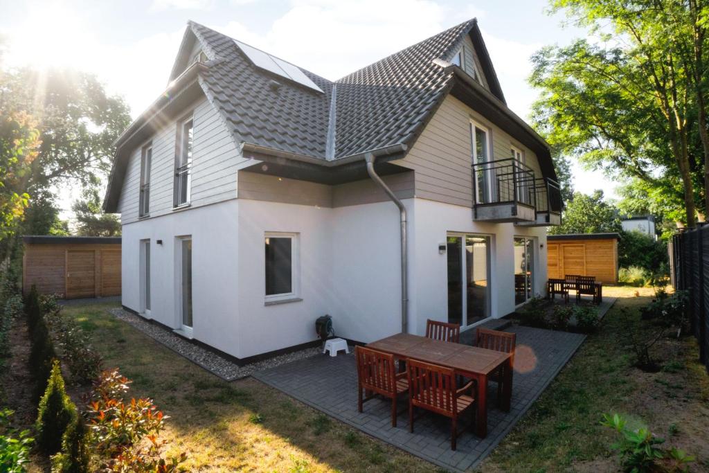 ヴィークにあるFerienwohnungen am Darßer Ort inkl Wäschepaketの小さな白い家(テーブルと椅子付)