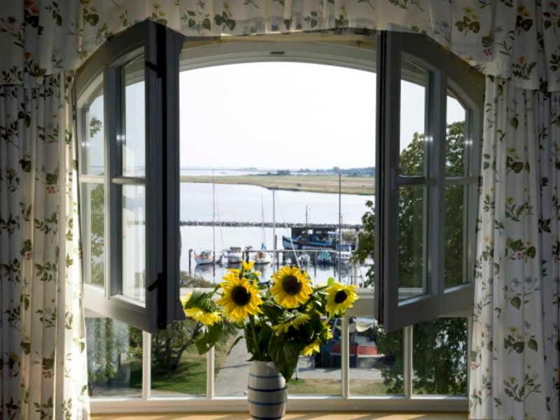 a vase of sunflowers sitting in a window at Hotel Hiddensee Hitthim in Kloster