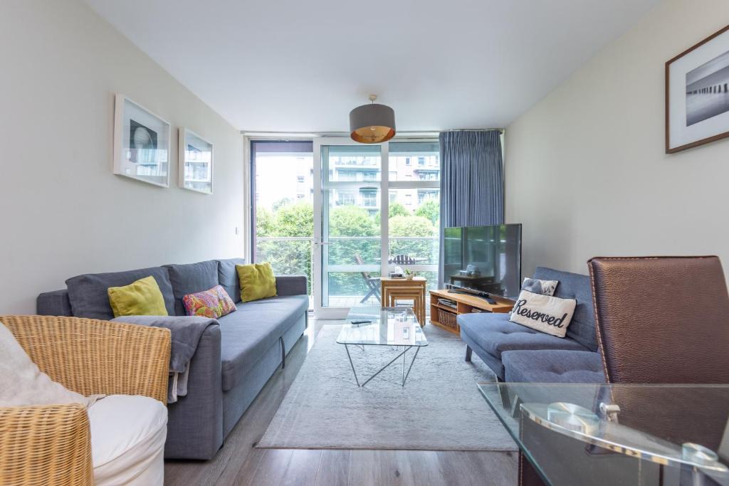 a living room with a couch and a tv at Riverside Apartment in London