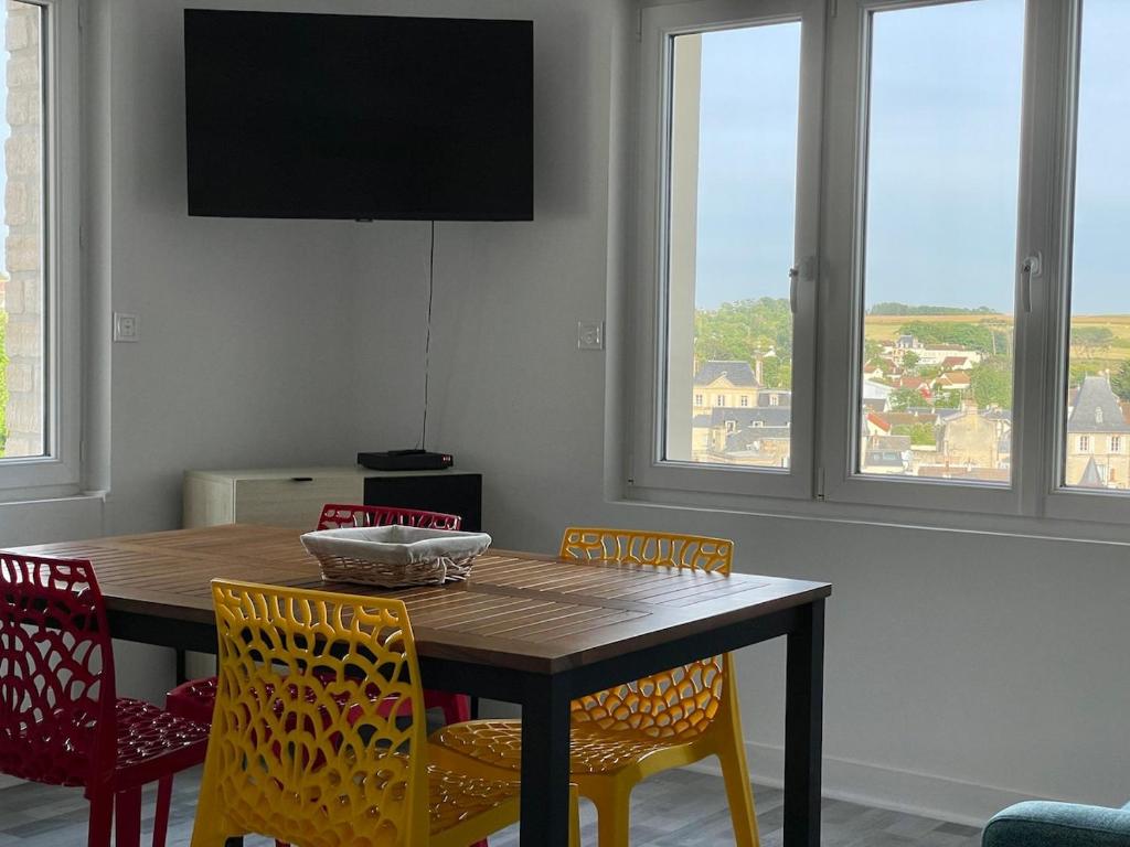 une table à manger avec des chaises et une télévision dans l'établissement Bellavista #3 by Melrose, à Arromanches-les-Bains