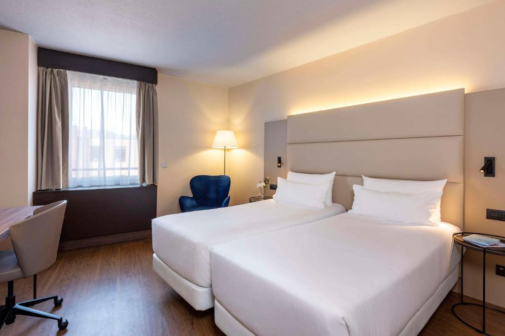Postel nebo postele na pokoji v ubytování NH Geneva Airport Hotel