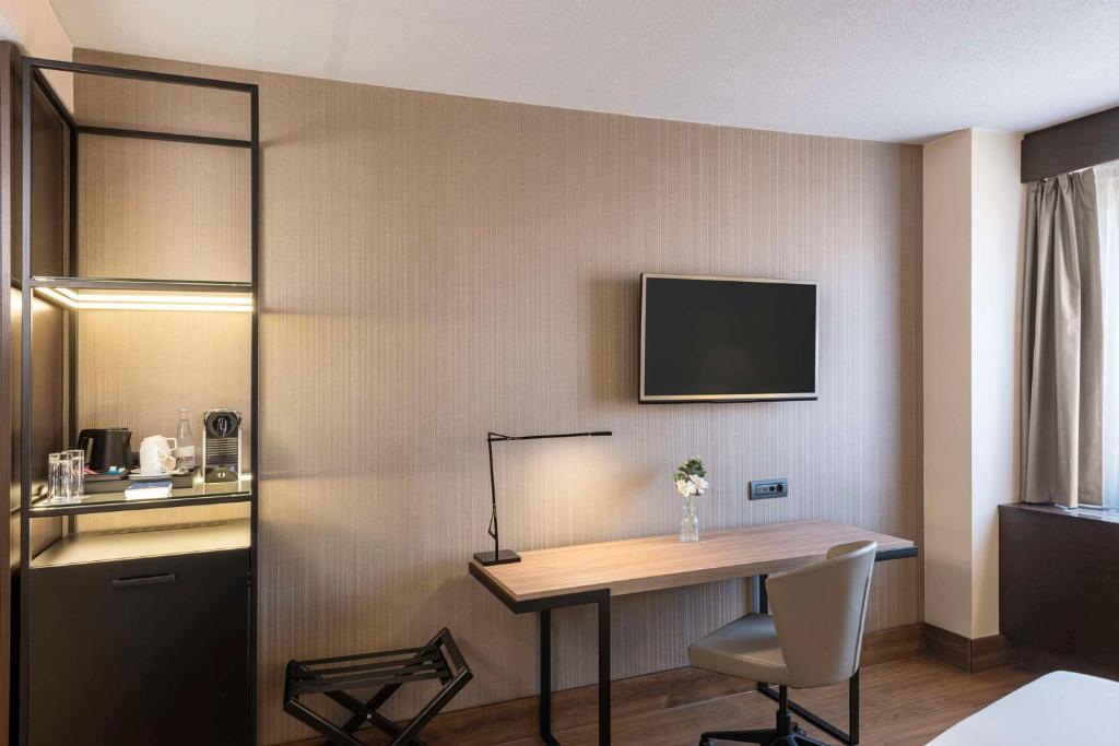 TV a/nebo společenská místnost v ubytování NH Geneva Airport Hotel