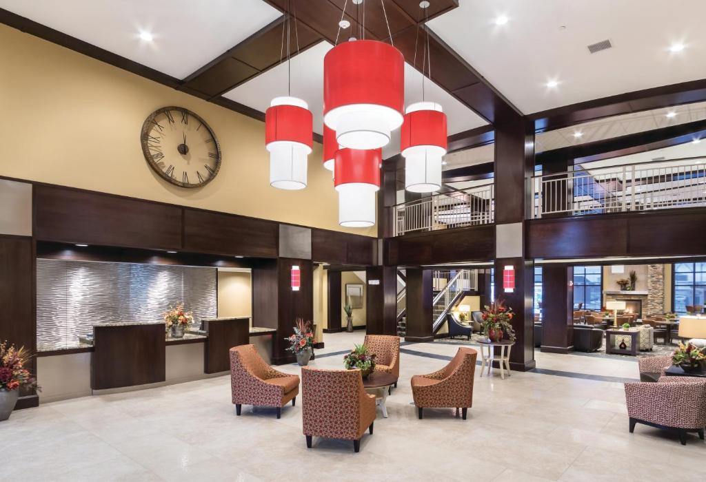 a lobby of a hotel with chairs and a clock at ClubHouse Hotel & Suites Fargo in Fargo
