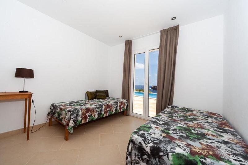 sypialnia z 2 łóżkami i oknem z widokiem na ocean w obiekcie Ficula Nou Beachfront Villa with private pool w mieście Punta Grossa