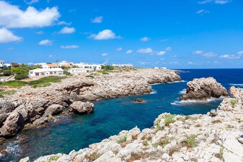 Skalisty brzeg z domami i oceanem w obiekcie Ficula Nou Beachfront Villa with private pool w mieście Punta Grossa