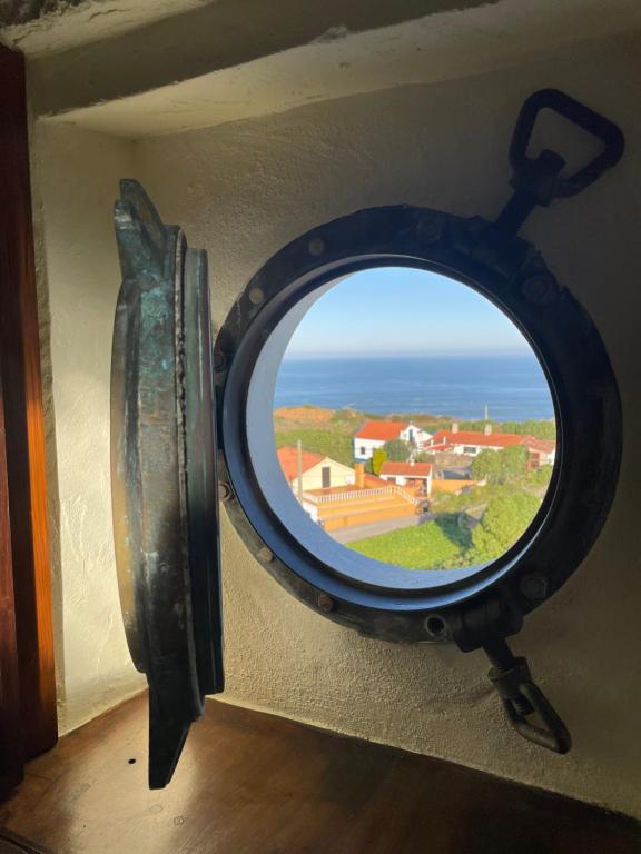 a mirror in a room with a view of the ocean at Moinho da Boavista in Serra do Bouro