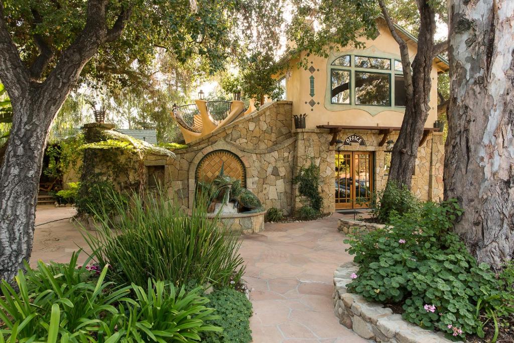 a home with a stone building with trees and plants at The Emerald Iguana Inn in Ojai