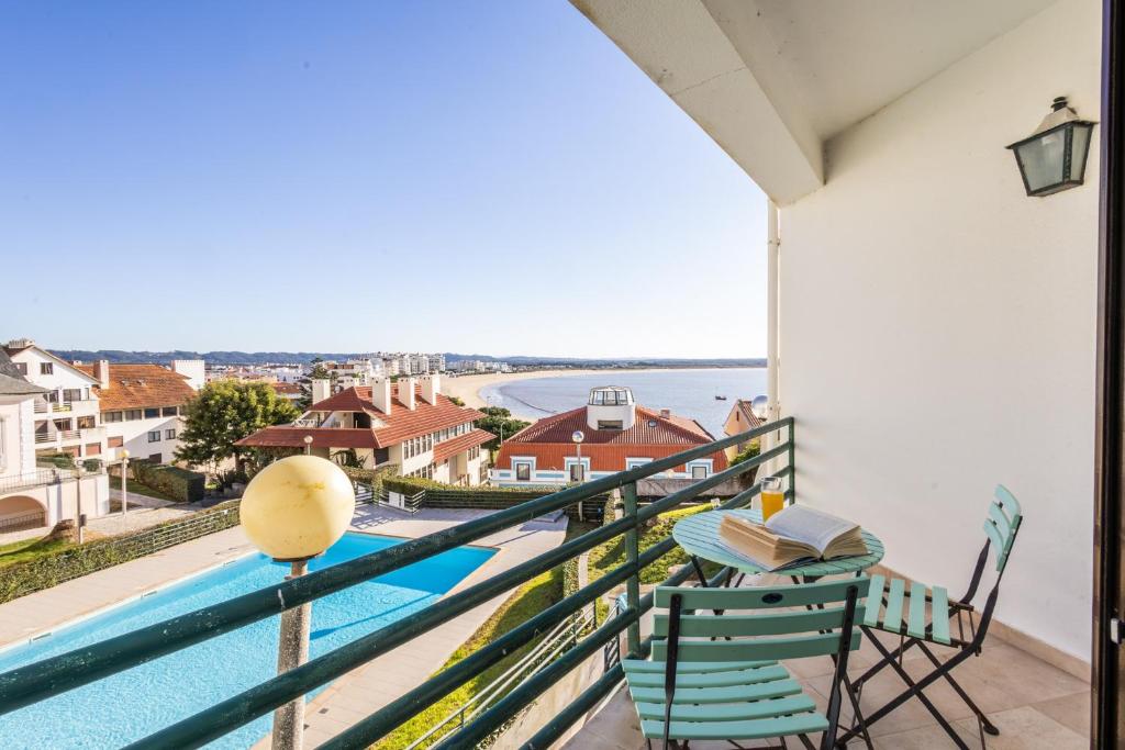 a balcony with a table and chairs and a pool at Paradise com vista sobre a baía in São Martinho do Porto