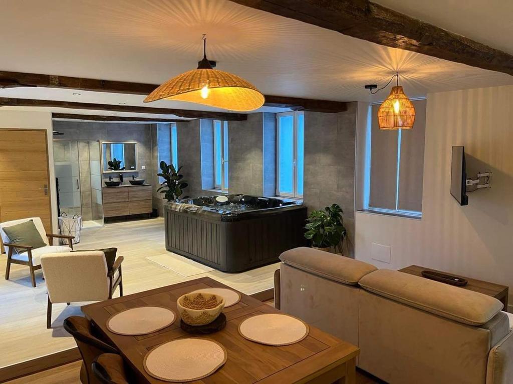 a living room with a couch and a table and a tub at Le Bonhomique in Seclin