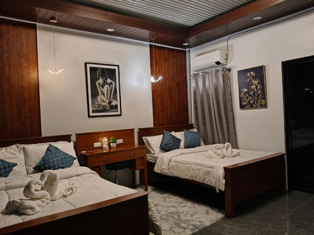 バコロドにあるGoldland Caelestis Guest Houseのタオルが敷かれたベッドが2つある寝室