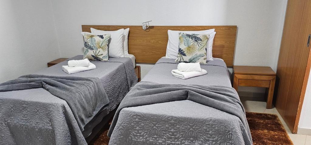 Habitación con 2 camas con mantas y almohadas grises en Sunset Star II With Sea View, en Calheta
