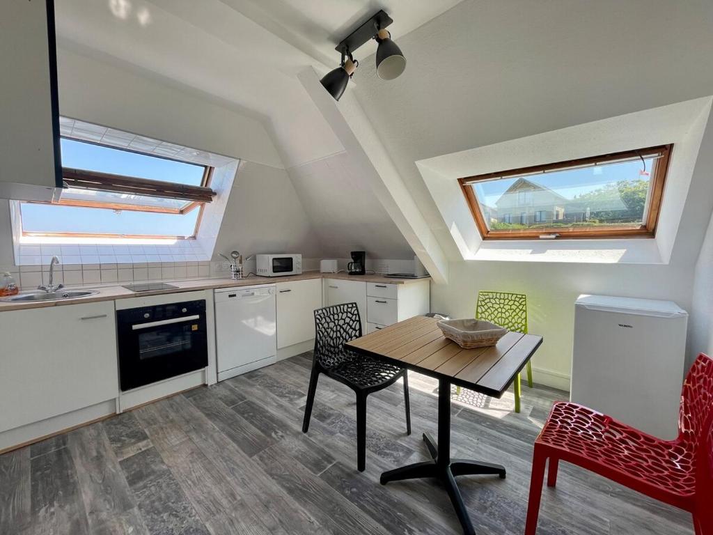 une cuisine avec une table et des chaises dans une pièce dans l'établissement Bellavista #9 by Melrose, à Arromanches-les-Bains