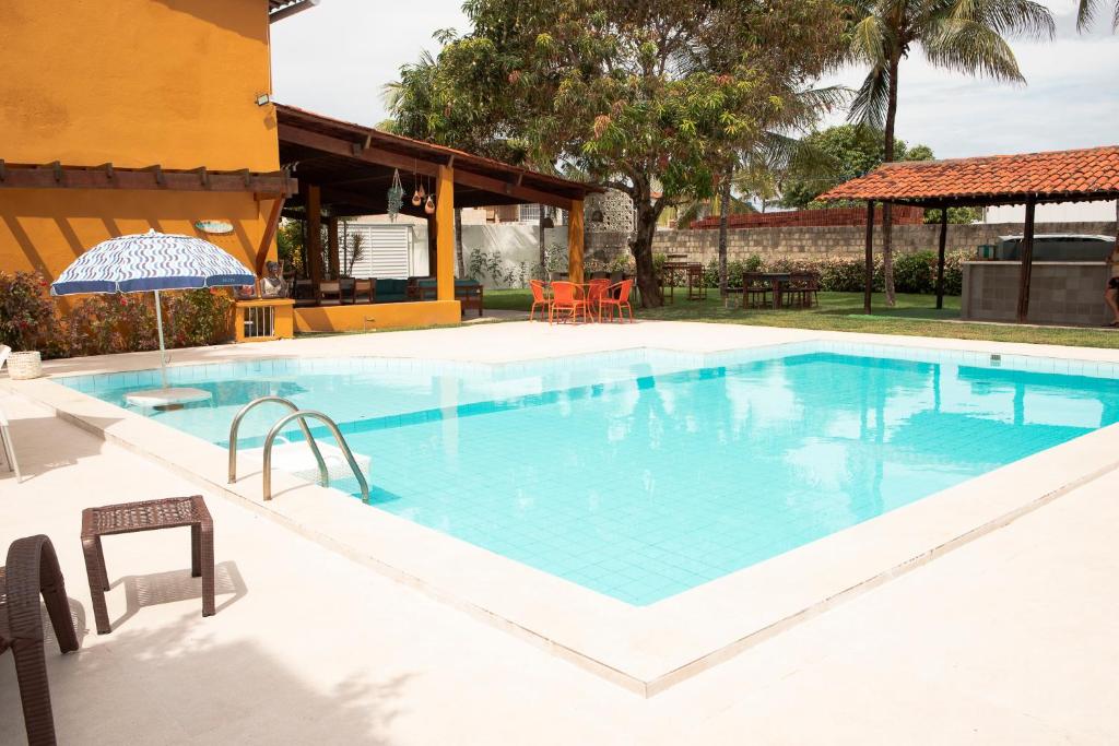 a large swimming pool with blue water at Casa da árvore com 5 suítes in Cabo de Santo Agostinho