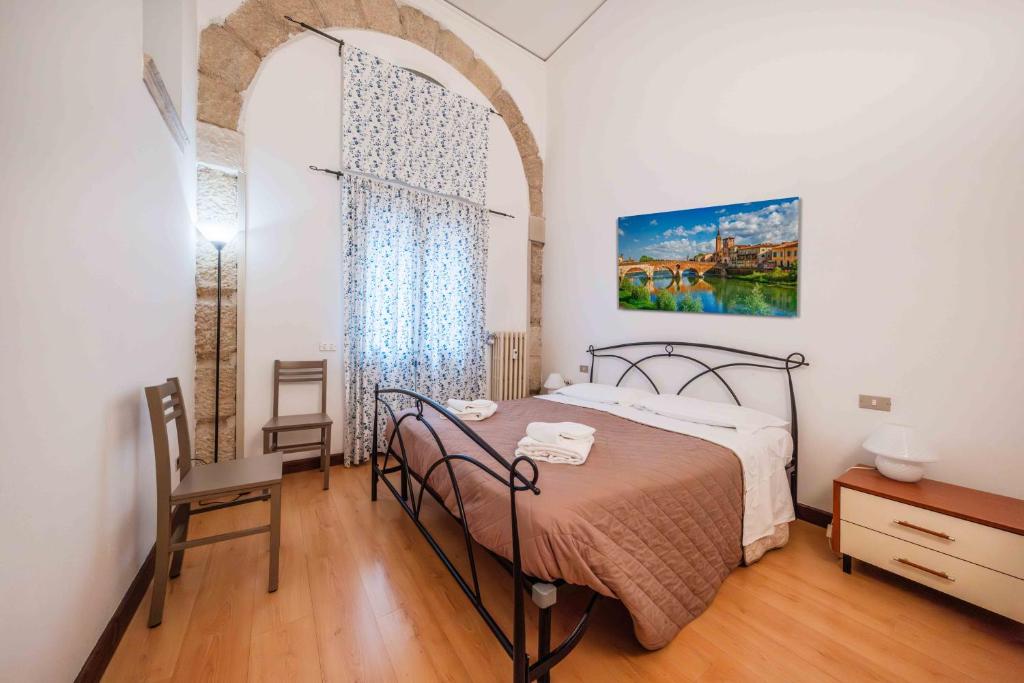 ヴェローナにあるRifugio Di Romeo e Giuliettaのベッドとテーブルと窓のある寝室