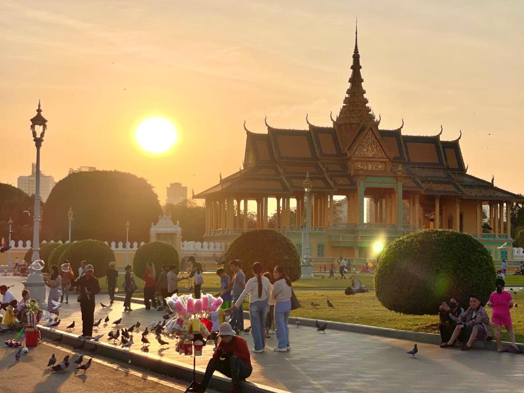 a group of people standing in front of a building with birds at Royal Riverside SkyHotel - Free Laundry in Phnom Penh