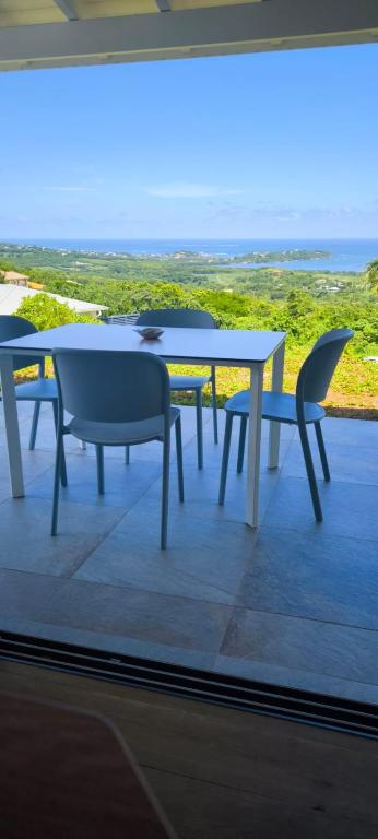 a table and chairs on a balcony with a view of the ocean at Lakay zot in Le Vauclin