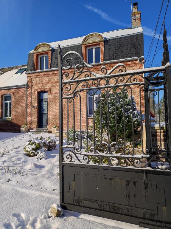 un portail en fer devant un bâtiment en briques dans l'établissement Le clos des Prêles, à Boismont