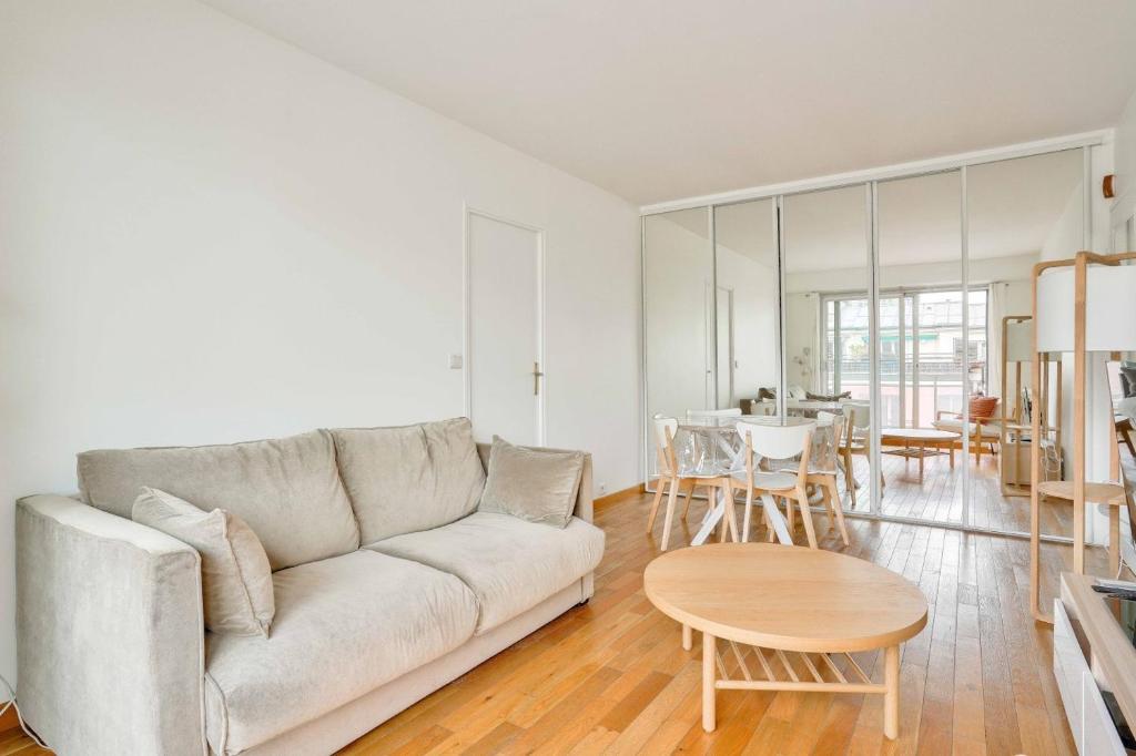 un salon avec un canapé et une table dans l'établissement GuestReady - Charming stay with a view, à Paris
