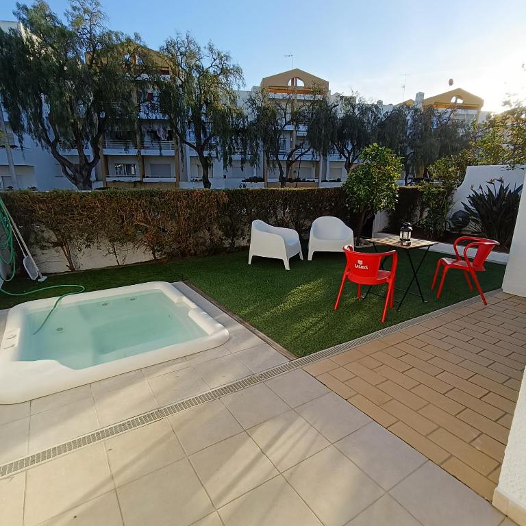 a backyard with a hot tub and chairs and a table at Lagos Charming Villas in Lagos