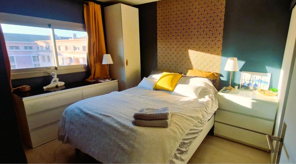 une chambre avec un lit avec des oreillers jaunes et une fenêtre dans l'établissement Le Ciel Bleu Clim Wifi Garage, à Aix-en-Provence