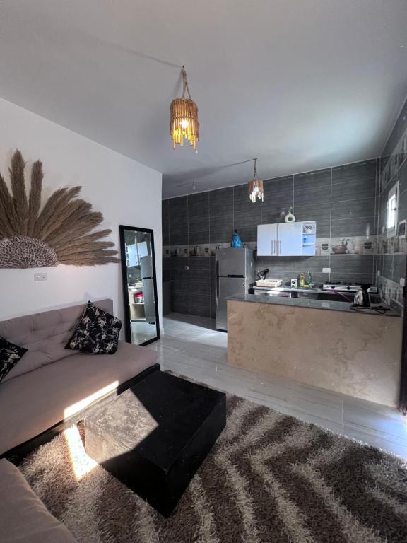 Una sala de estar con un sofá y una cocina. en Warrior rest, en Dahab