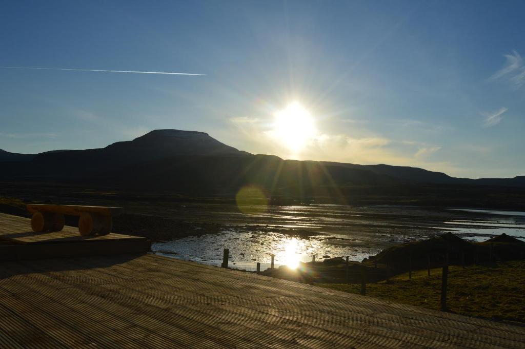 a sun setting over a body of water with a mountain at The Tide in Dunvegan
