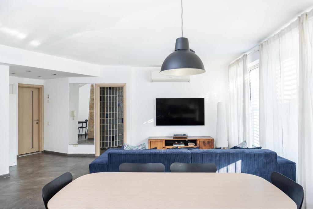 a living room with a table and a tv at Best Location 3BR Specious Apartment By Vacay in Tel Aviv