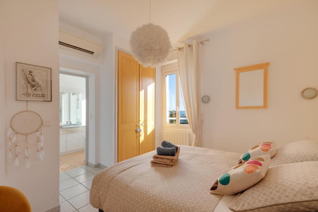 une chambre blanche avec un lit et une fenêtre dans l'établissement Villa Anaite Vue mer et montagne, piscine privée, à Antibes