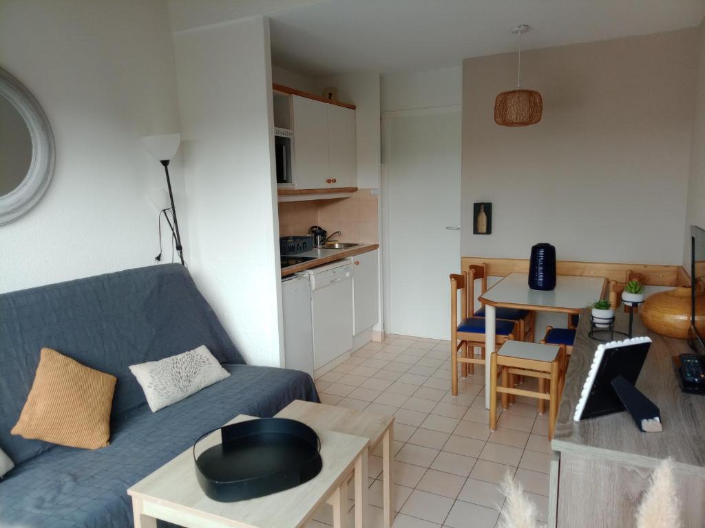 un salon avec un canapé bleu et une table dans l'établissement Studio port, lac, plage, à Talmont-Saint-Hilaire