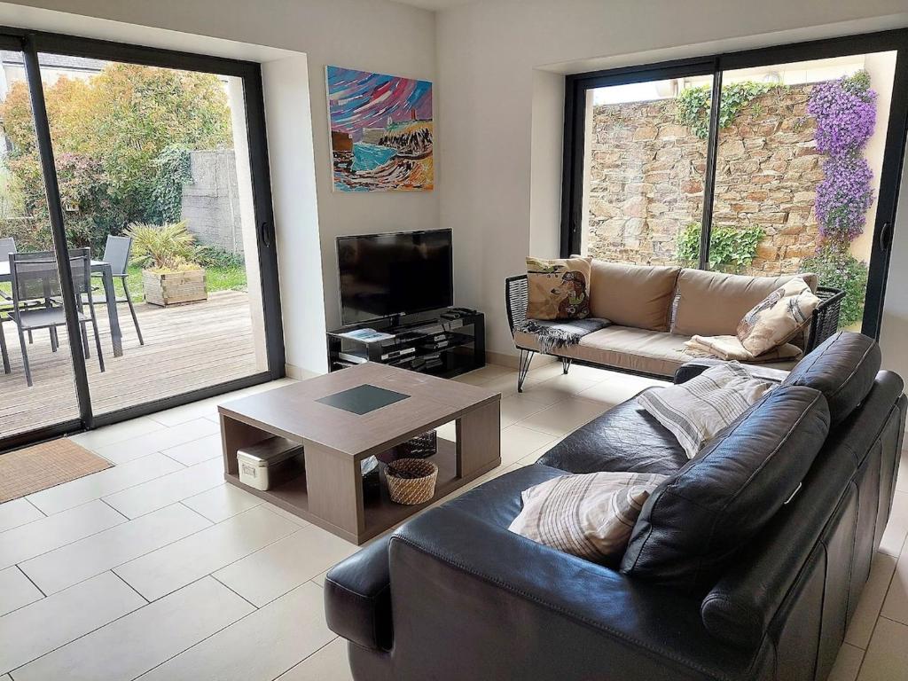 un salon avec un canapé et une table dans l'établissement Ty Mélanie maison avec jardin, à Fouesnant