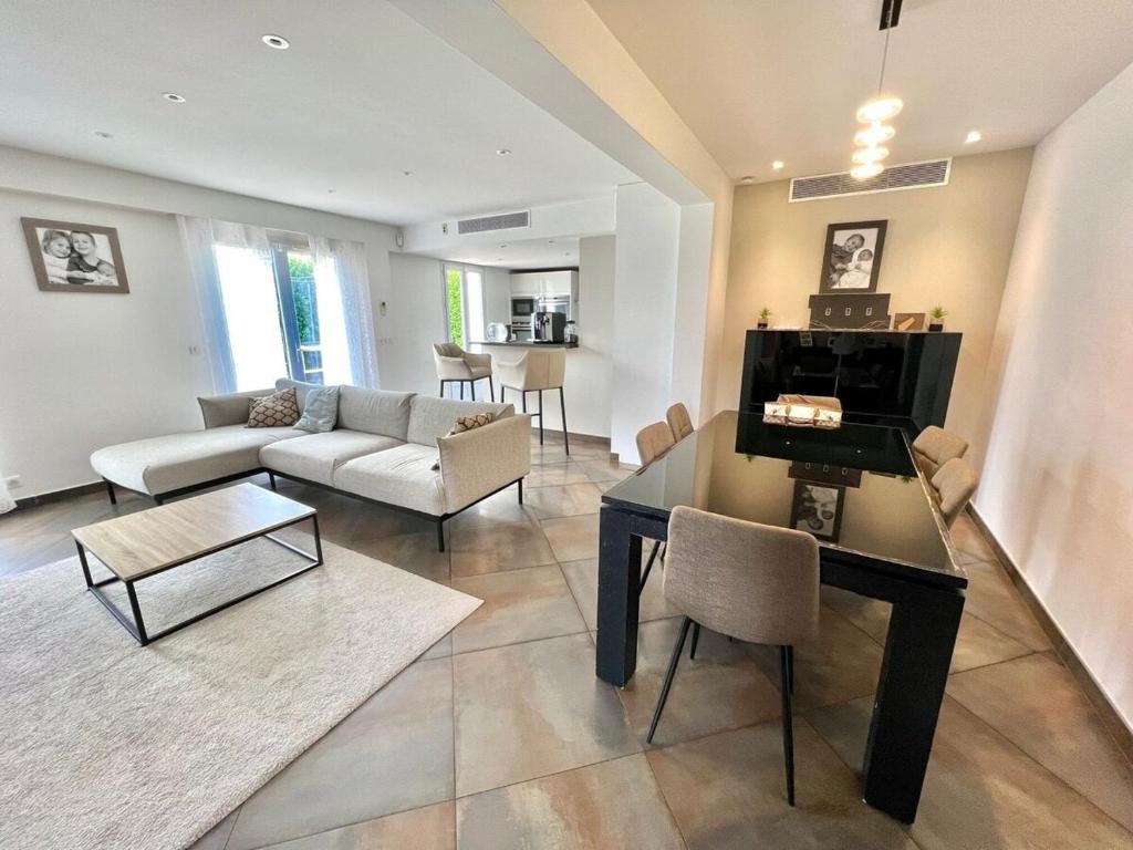 un salon avec un canapé, une table et des chaises dans l'établissement Single-family home in Mandelieu, à Mandelieu-la-Napoule
