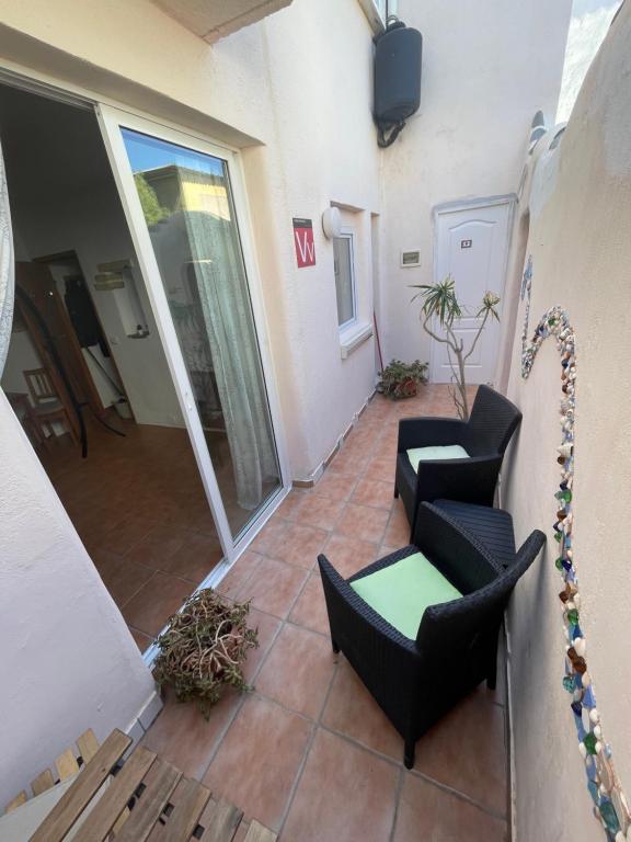 a balcony with two chairs and a table at La Tejita Studio in La Tejita